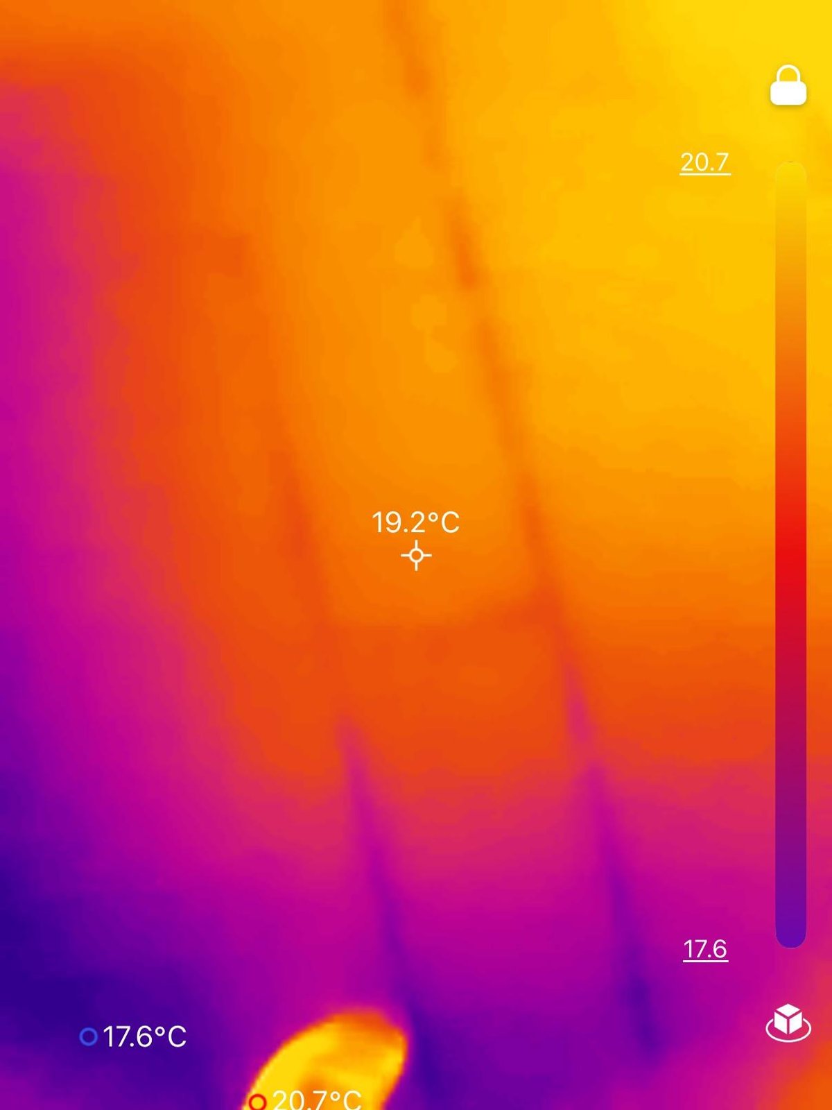 Thermal camera view of a wall showing temperature variation, with diagonal cooler lines and a warm spot at the bottom.